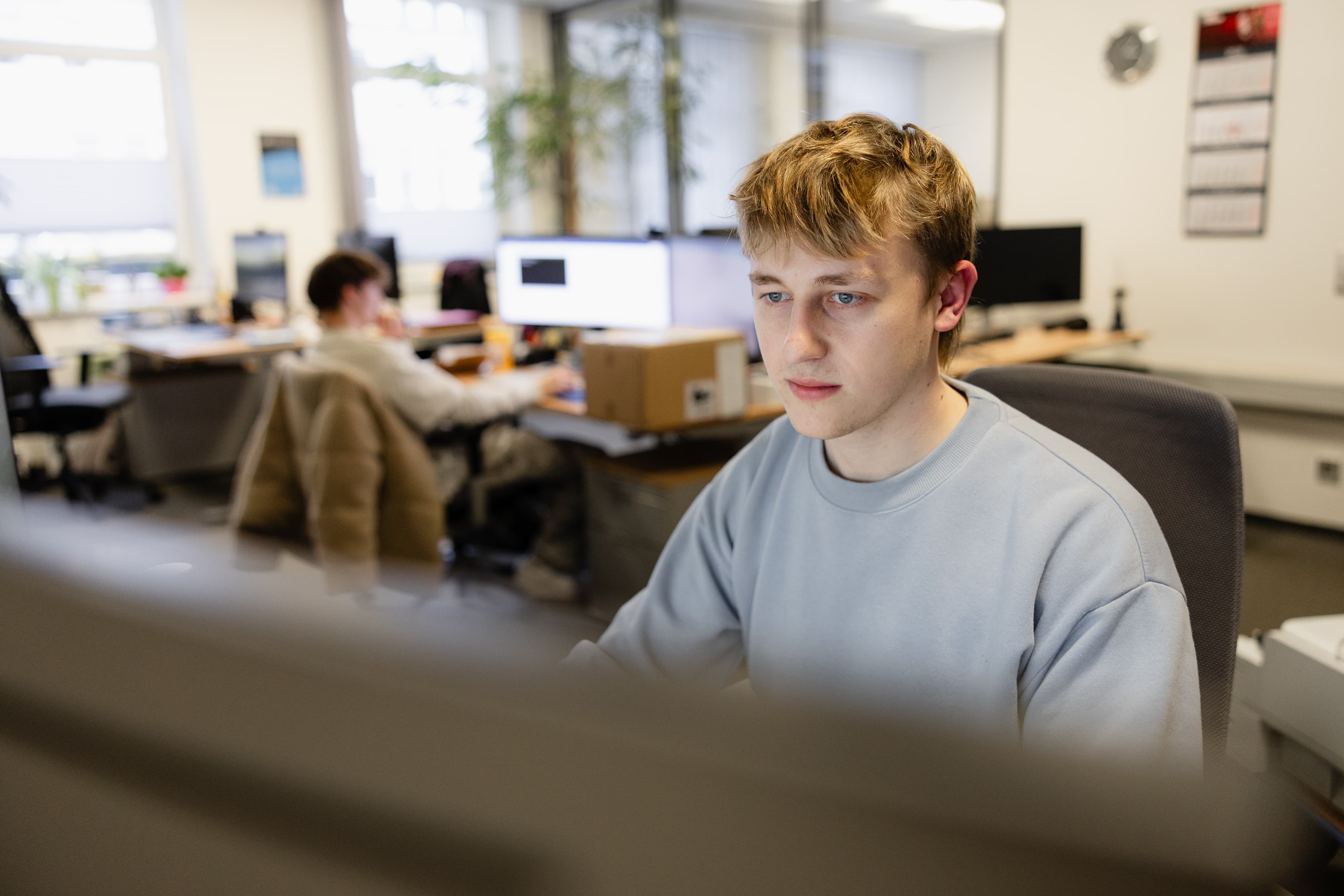 Ein junger Mann schaut auf seinen Bildschirm