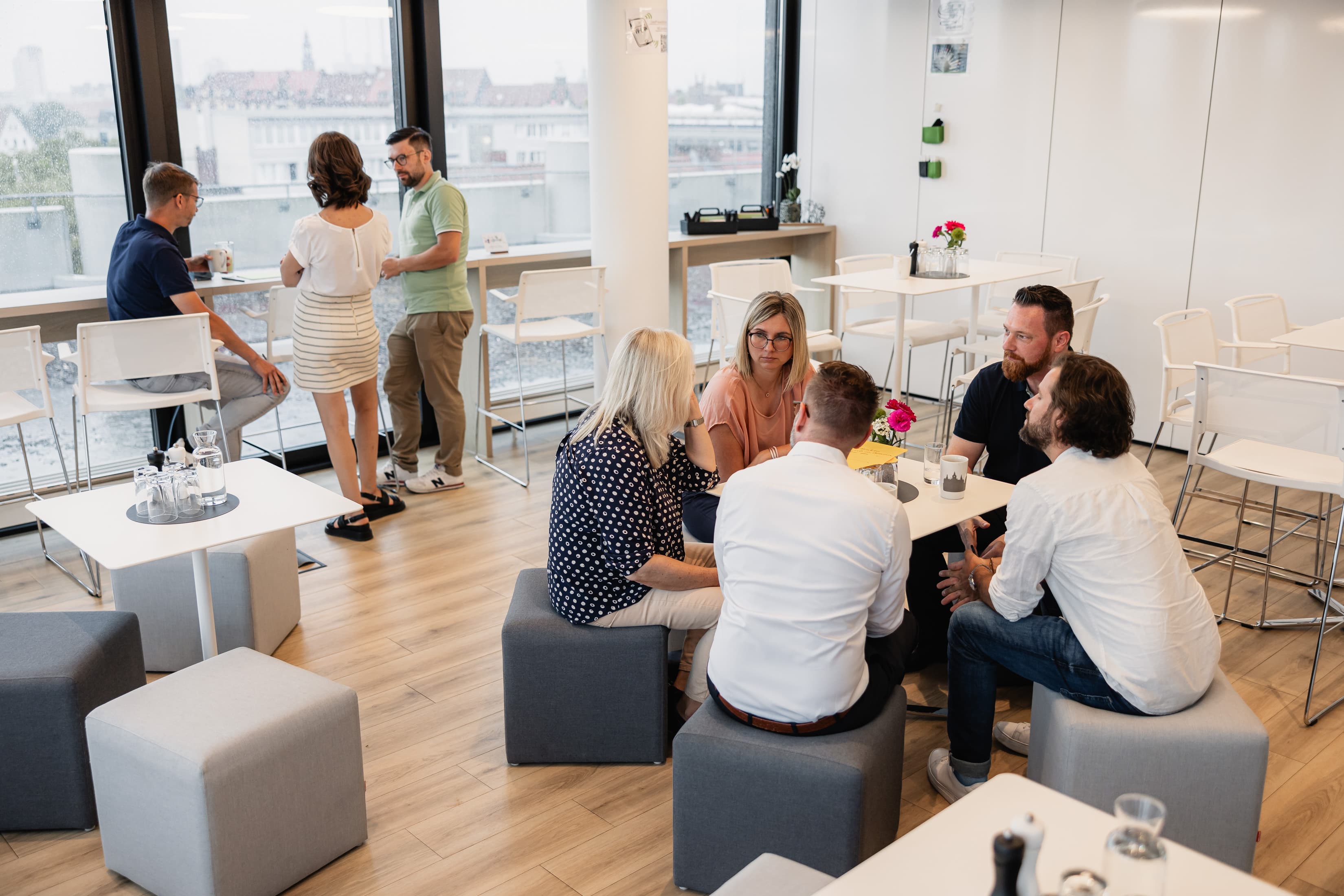 Netzwerken außerhalb des Arbeitsalltags Führungskräfte der WERTGARANTIE Group sitzen an einem Tisch und sind miteinander im Gespräch zum Netzwerken.