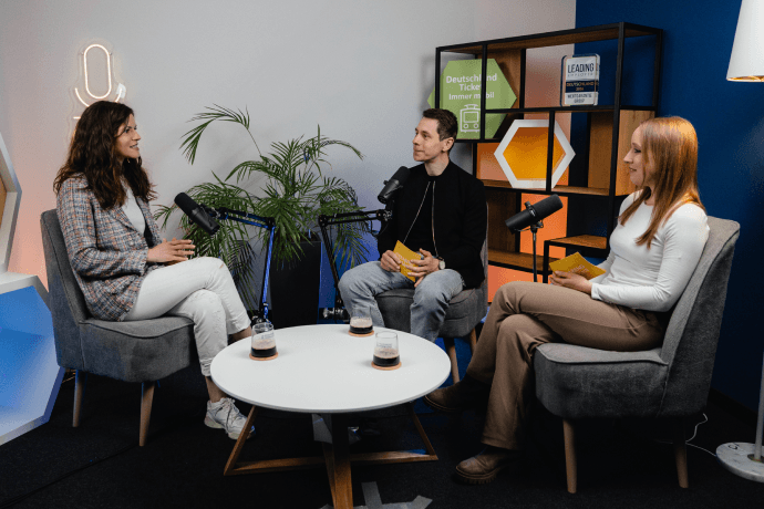 Folge 6 mit Viktoria Bereichsleiterin Customer Experience Management Viktoria sitzt in unserem Podcaststudio. Vor ihr ist ein Mikrofon aufgebaut.