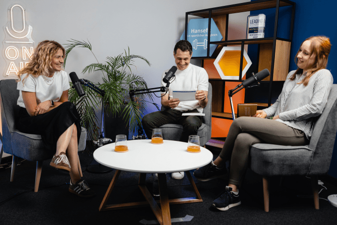 Folge 7 mit Regine Personalentwicklerin Regine sitzt in unserem Podcaststudio. Vor ihr ist ein Mikrofon aufgebaut.