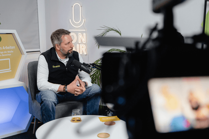 Folge 8 mit Carsten Verkaufsleiter für Fachhandel und Kooperationen Carsten sitzt in unserem Podcaststudio. Vor ihm ist ein Mikrofon aufgebaut.