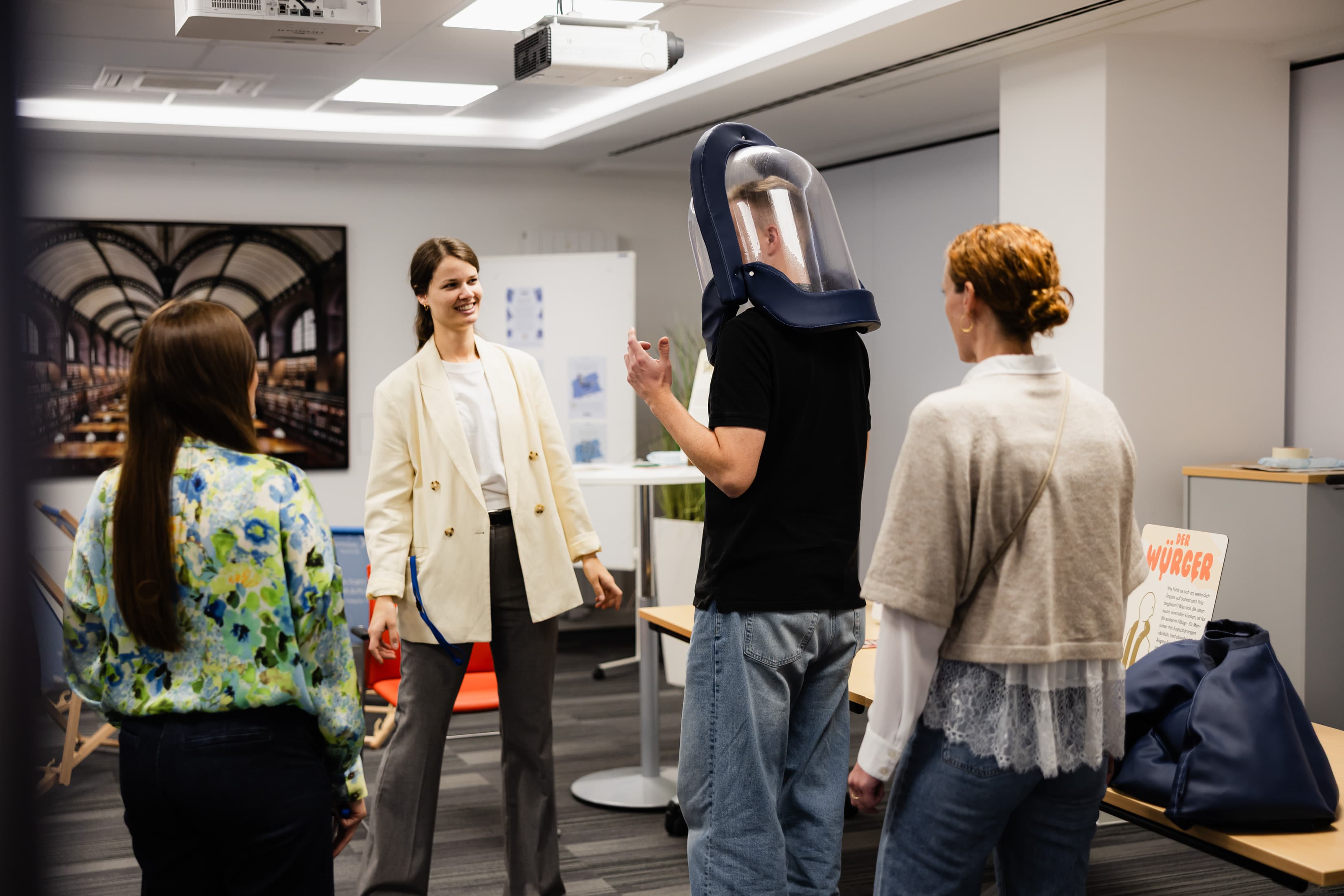 Gesundheitstage Vier Mitarbeitende der WERTGARANTIE Group probieren beim Besuch der internen Gesundheitstage die MOODSUITS aus.